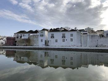 Reflection of buildings in lake against sky