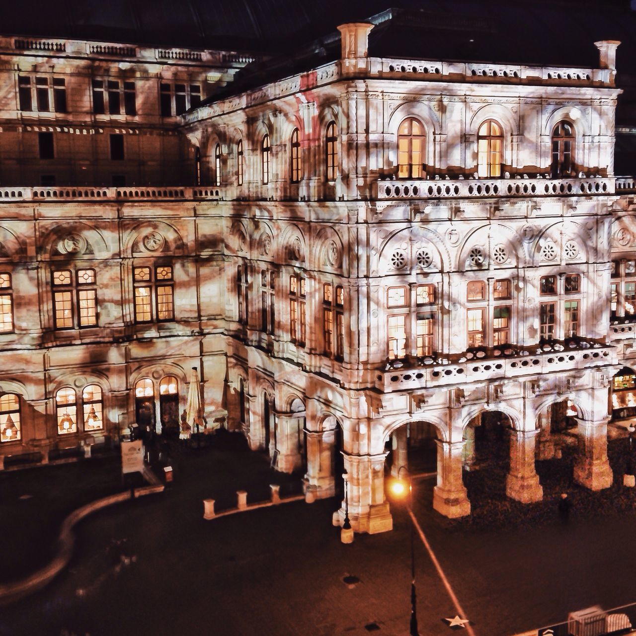 architecture, built structure, building exterior, illuminated, night, street, street light, city, building, arch, car, transportation, road, lighting equipment, land vehicle, incidental people, outdoors, city life, no people, sky