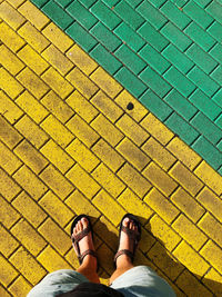 Low section of man standing on tiled floor