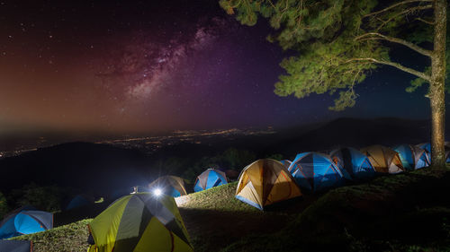 Night scene camping and tent pine forest and city light with star background at doi angkhang, 