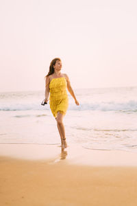 Full length of woman standing at beach