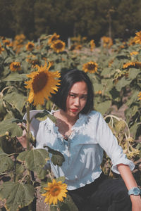 Young woman standing on yellow flowering plants