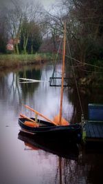 Boat moored on lake against sky