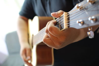 Midsection of man playing guitar