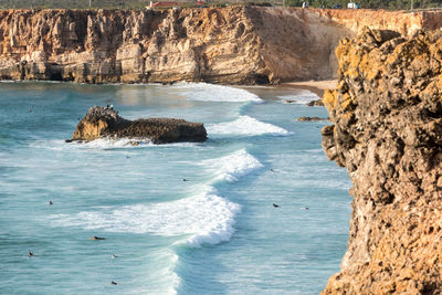 Scenic view of sea by cliff