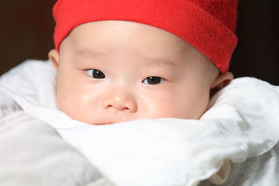 Close-up of cute baby girl sleeping on bed
