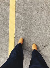 Low section of man standing on road