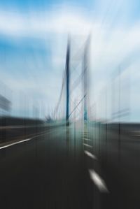 Blurred motion of bridge in city against sky