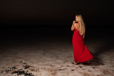 Young blond woman in red clothing posing and doing modeling on the salt lake of larnaca