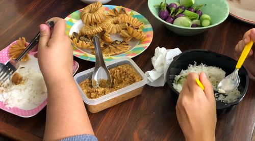 High angle view of hand holding food on table