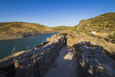 Scenic view of river against clear blue sky