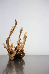 Driftwood on table against sea against sky