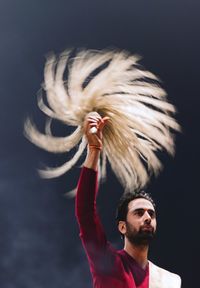 Low angle view of man holding praying equipment