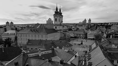 High angle view of city buildings against cloudy sky