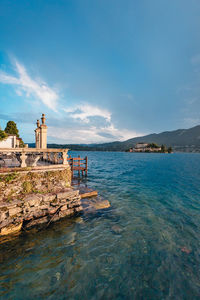 View of a building on lake orta with the island of san giulio in the background