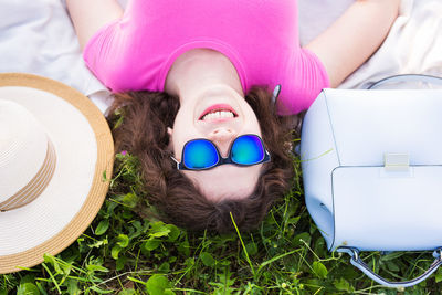 Portrait of young woman lying down in sunglasses