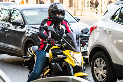 Man riding motorcycle on road in city