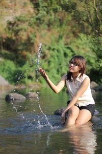 Young woman sitting in water