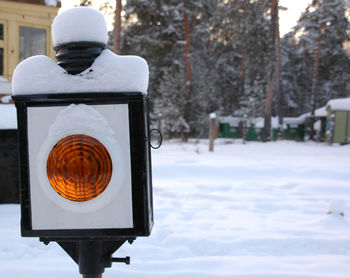 Close-up of stoplight on snowcapped field during winter