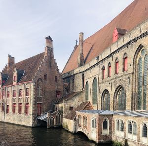 Arch bridge over canal and buildings against sky