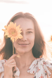 Portrait of a smiling young woman holding flower