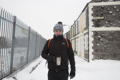 Full length of man standing on snow covered street during winter