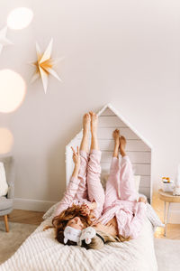 Happy girls friends in pajamas communicate laugh at a bachelorette party in a cozy bedroom house