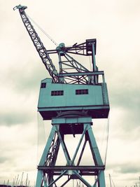 Low angle view of crane against sky