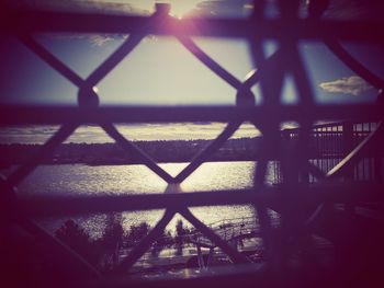 Metal fence against sky seen through window