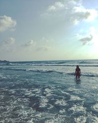 Men in sea against sky