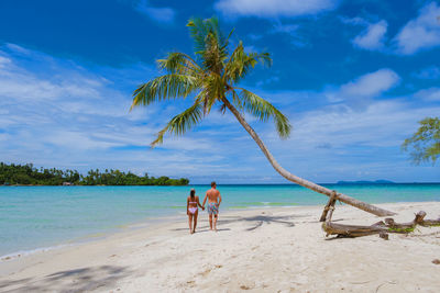 People at beach against sky