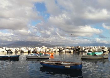 Boats moored in sea against sky