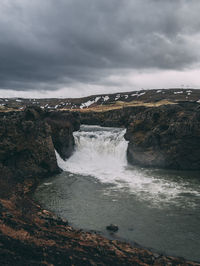 Scenic view of waterfall against sky