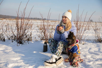 Rear view of woman standing on snow covered field