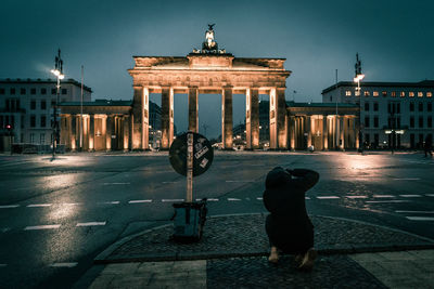 Statue of woman in city at night