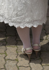 Low section of woman standing on footpath