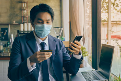 Full length of man using mobile phone