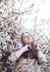 Portrait of a young woman in a spring blossom tree