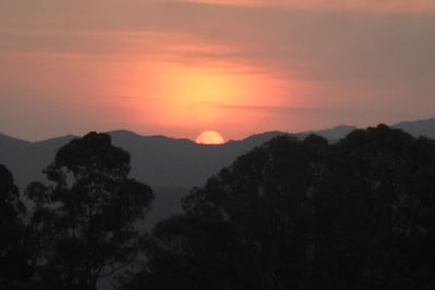 Scenic view of silhouette mountains against romantic sky at sunset