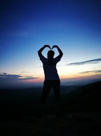 Silhouette man standing on landscape against clear sky