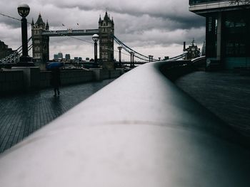 Suspension bridge against cloudy sky