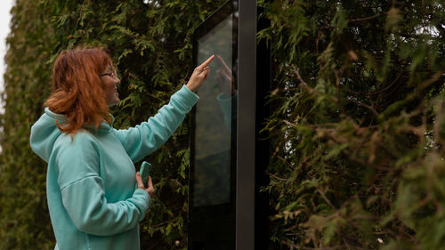 Rear view of woman standing against plants