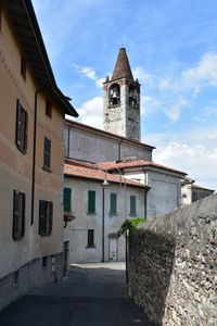 Low angle view of houses by church against sky