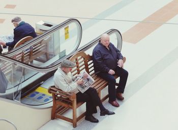 Rear view of people sitting in corridor