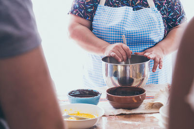 Midsection of women preparing food at table