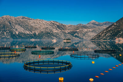 Scenic view of lake and mountains against clear blue sky