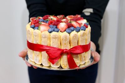 Midsection of person holding cake