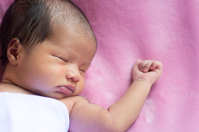 Close-up of baby girl sleeping on bed