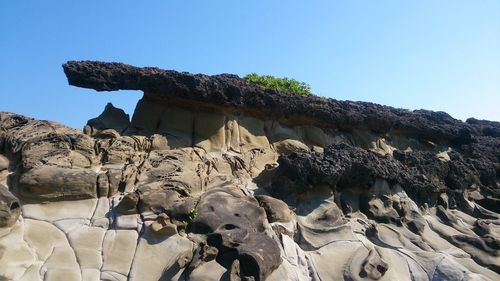 Low angle view of rock formation against clear sky