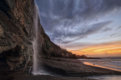 Waterfall on the beach during sunset